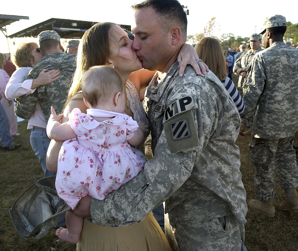 US Army Staff Sgt. Davis Wolfe kisses his wife, Kristine, and greets his 13-month-old daughter, Faith, in 2006.
US Army Staff Sgt. Davis Wolfe kisses his wife, Kristine, and greets his 13-month-old daughter, Faith, in 2006.