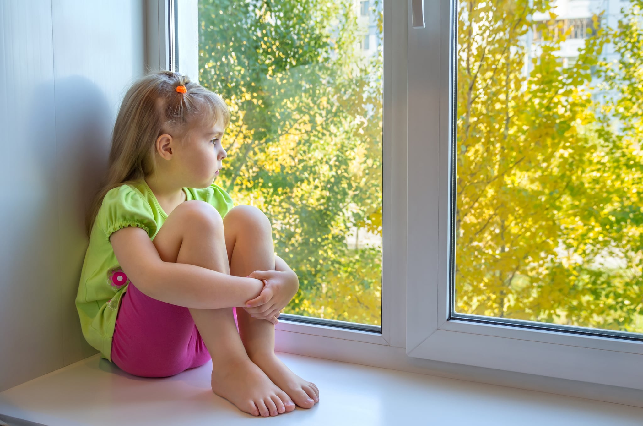 Девочка сидит у окна