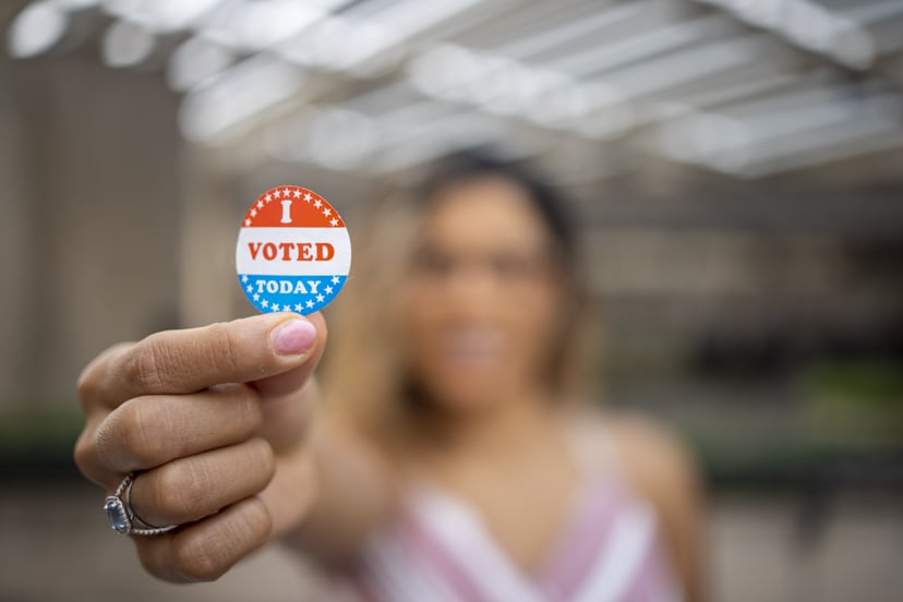A young Hispanic woman with her I voted sticker after voting in an election.