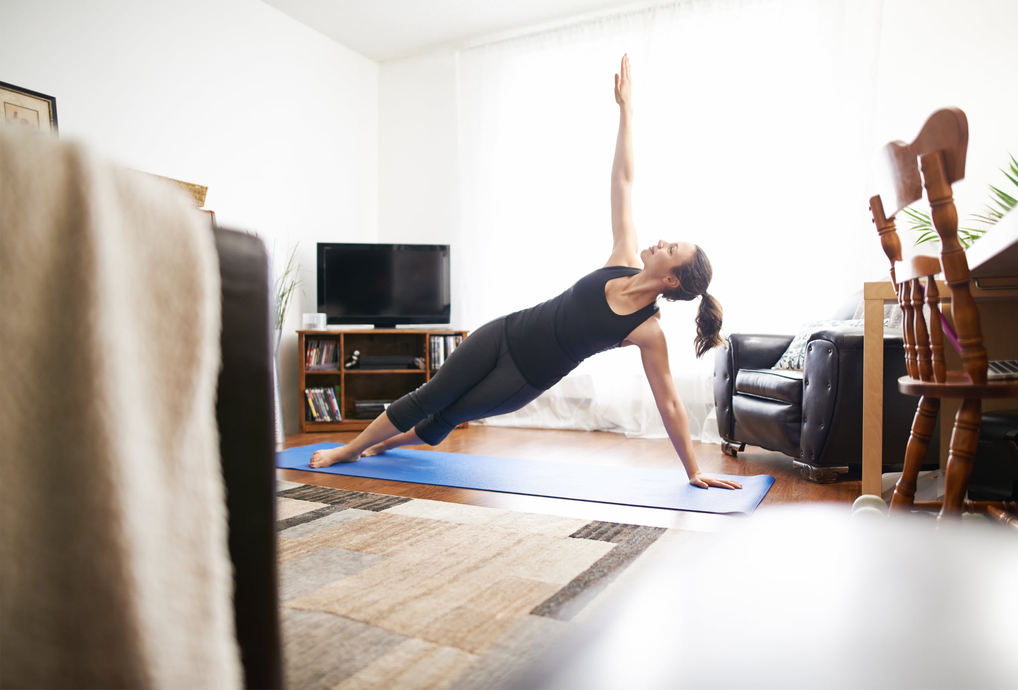 Full length shot of a young woman practicing yoga at home