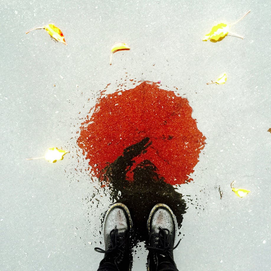 "Shooting your subject in a reflection — like the one on this wet street — can make a simple scene seem surreal and surprising."