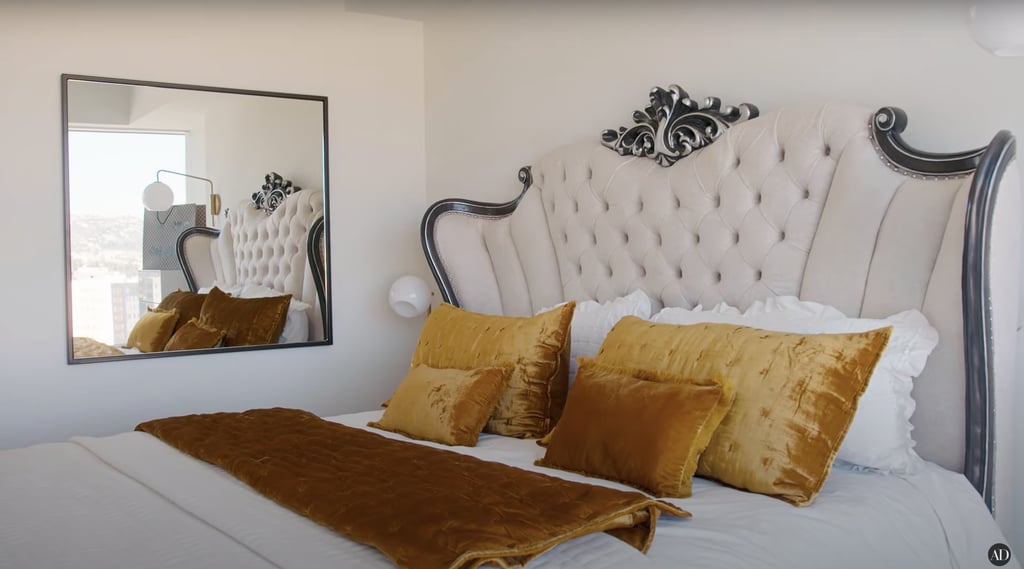 Her queen-sized bed was a gift from her godmother and is decorated with yellow velvet pillows.