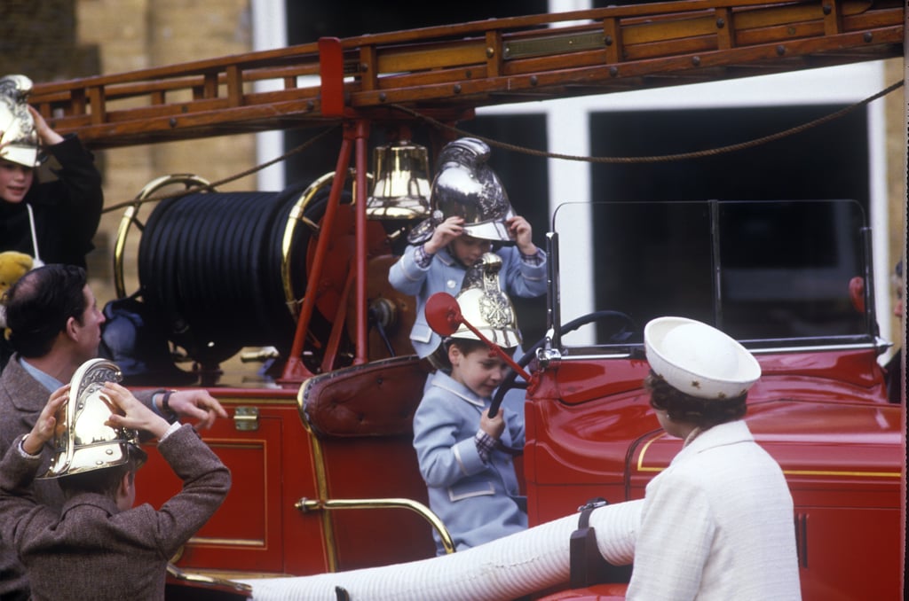 Queen Elizabeth watches Prince Harry and Prince William play on a fire truck in 1988.
