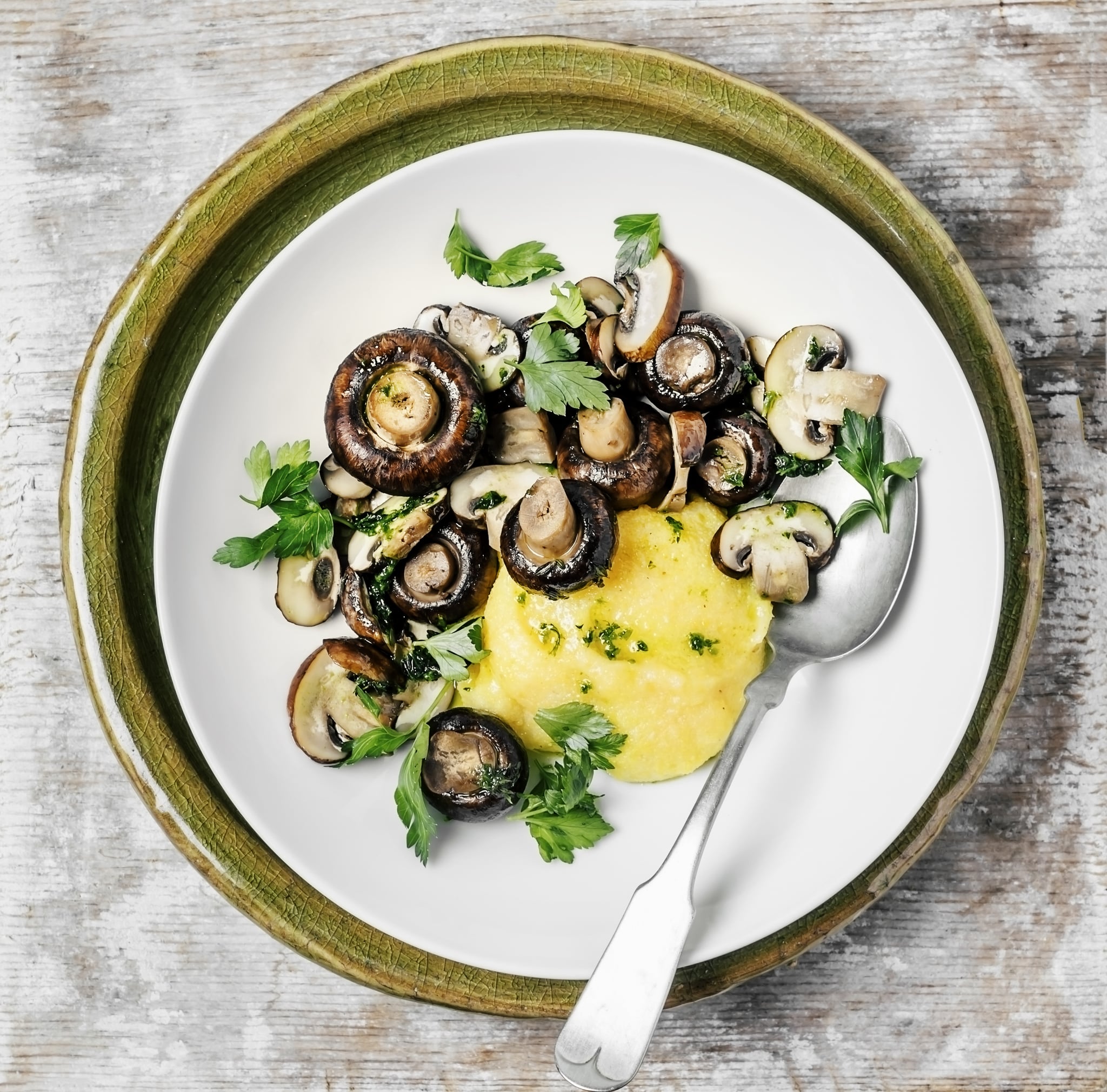 A plate of polenta with mushrooms on wooden background