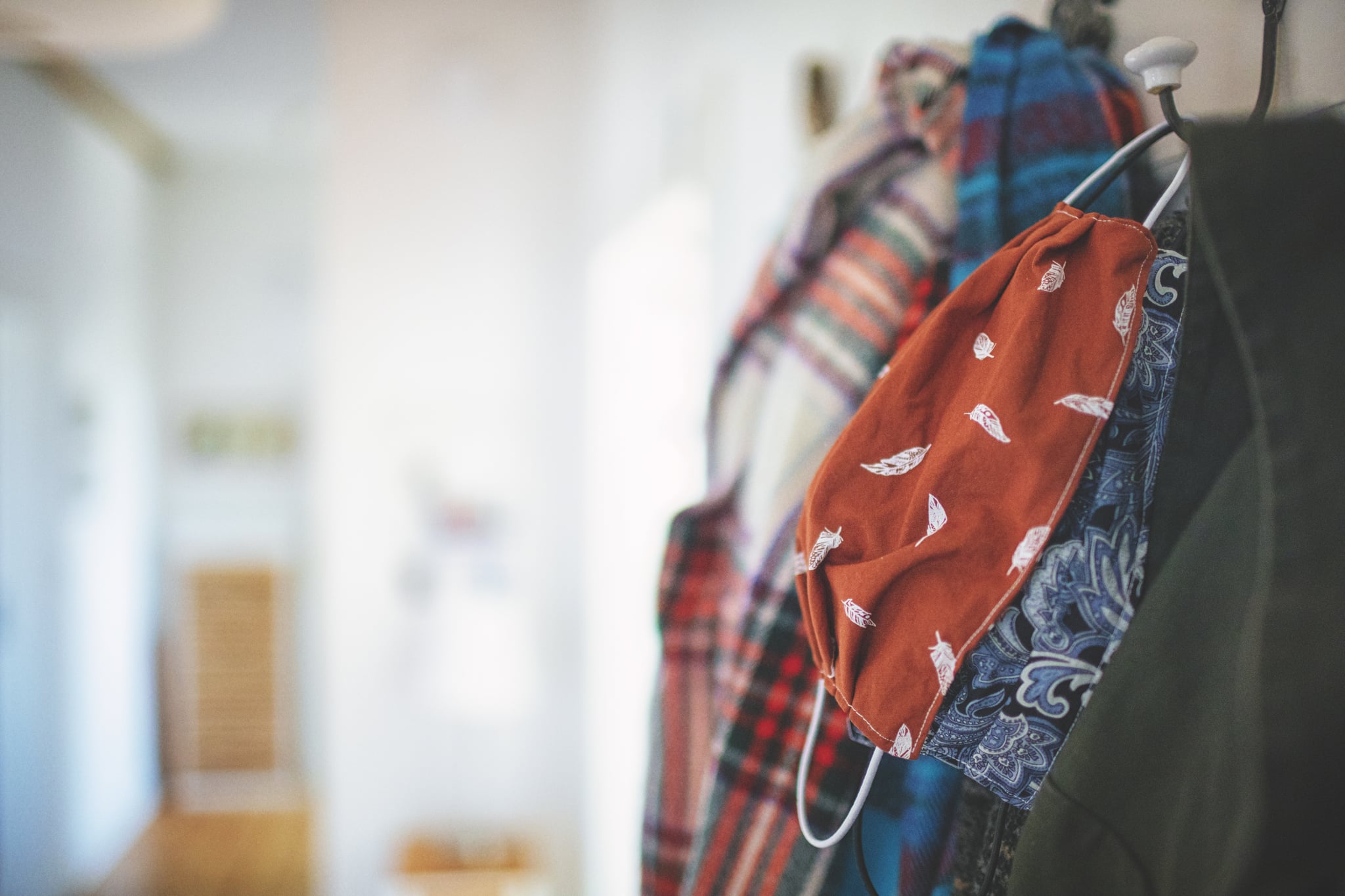 Self-sewn mouth protection on the wardrobe with the jackets in the hallway