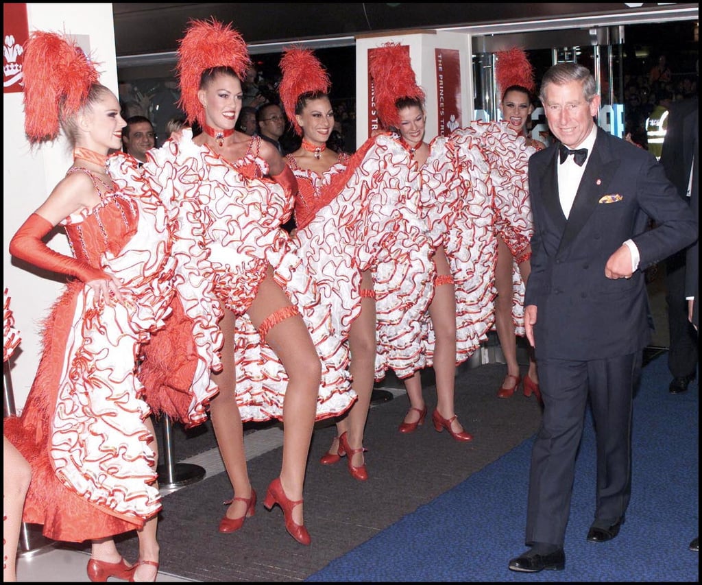 Prince Charles couldn't help but grin as he passed a group of dancers at the Moulin Rouge premiere in 2001.