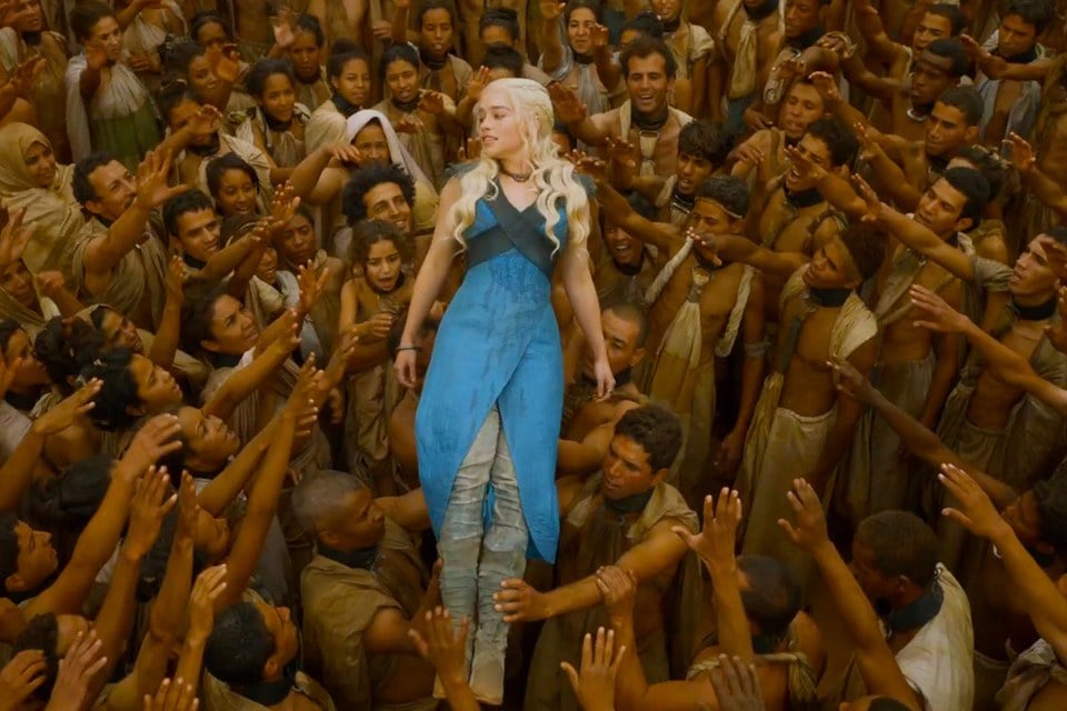 Daenerys Targaryen "Khaleesi" is being lifted up by the slaves of Meereen. A mass of people reaching out to her while crying "Mhysa," which means mother. 