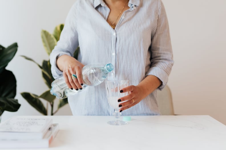 woman pouring sparkling water into a glass; is sparkling water good or bad for you?