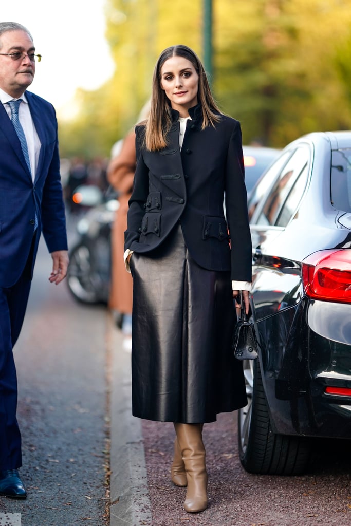 Olivia stuck to classics with this Paris Fashion Week look, adding interest with a leather finish on her midi skirt and a pair of knee-high boots.