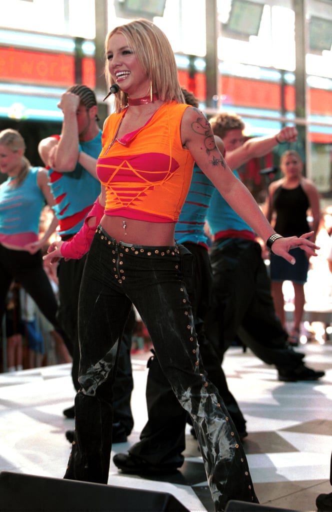 Performing in a cutout crop top and studded trousers.