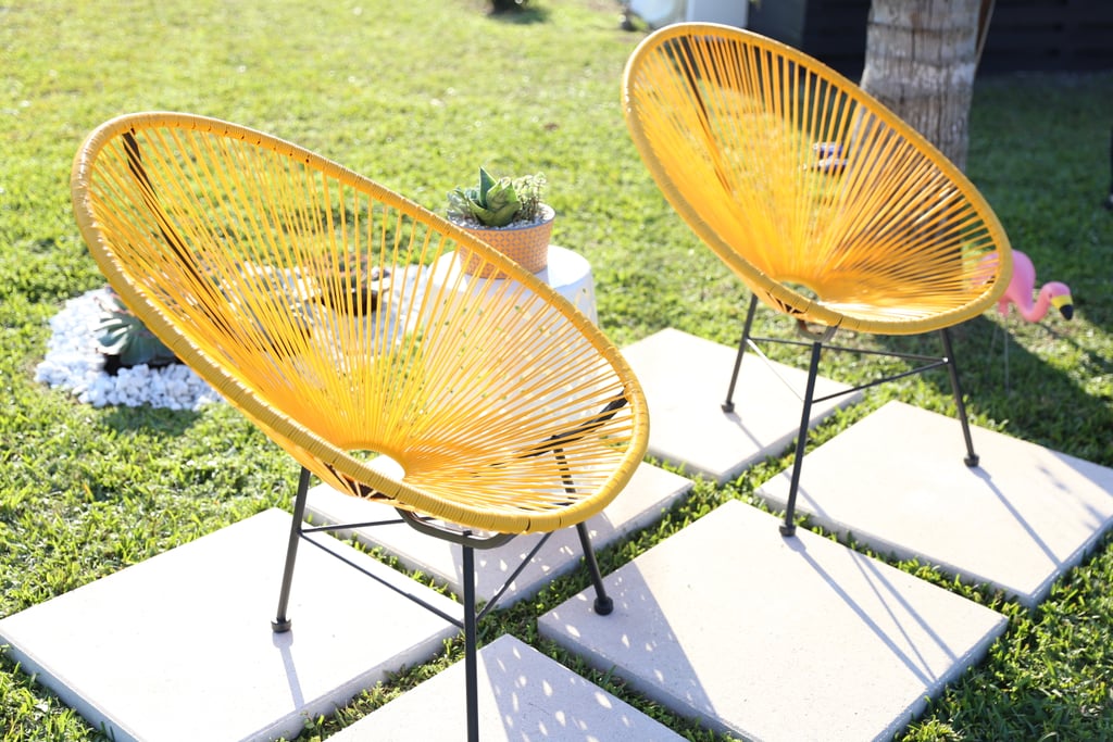 Want a money-saving tip? Don't pay to have an expensive deck or patio built: simply lay down a few pavers. Monica placed six square white paver stones ($9 each) on a level area of lawn and topped them with a pair of charming, midcentury lounge-style chairs ($318), et voila! It's the perfect place to watch the sunset.