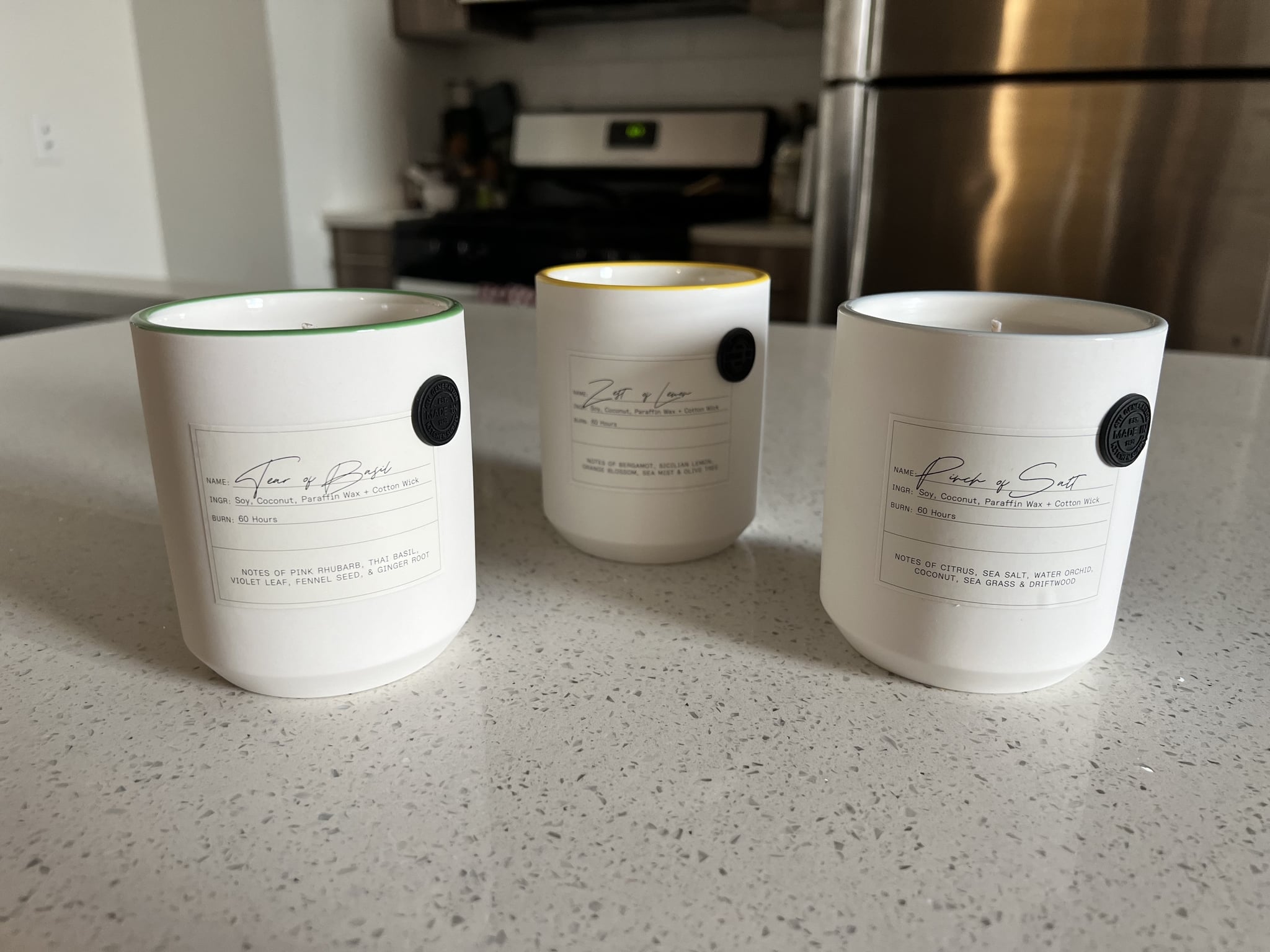 Made In's Kitchen Candles in Zest of Lemon, Tear of Basil, and Pinch of Salt on kitchen countertop.