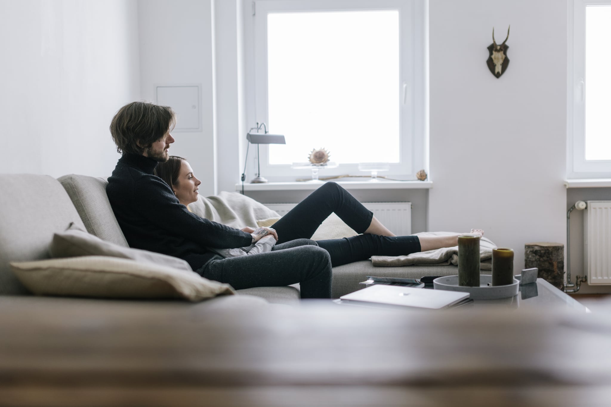 Young couple snuggling on couch