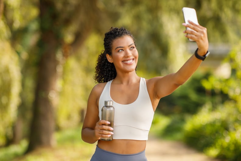 Running influencer exercising and taking a selfie outdoors, performative running.