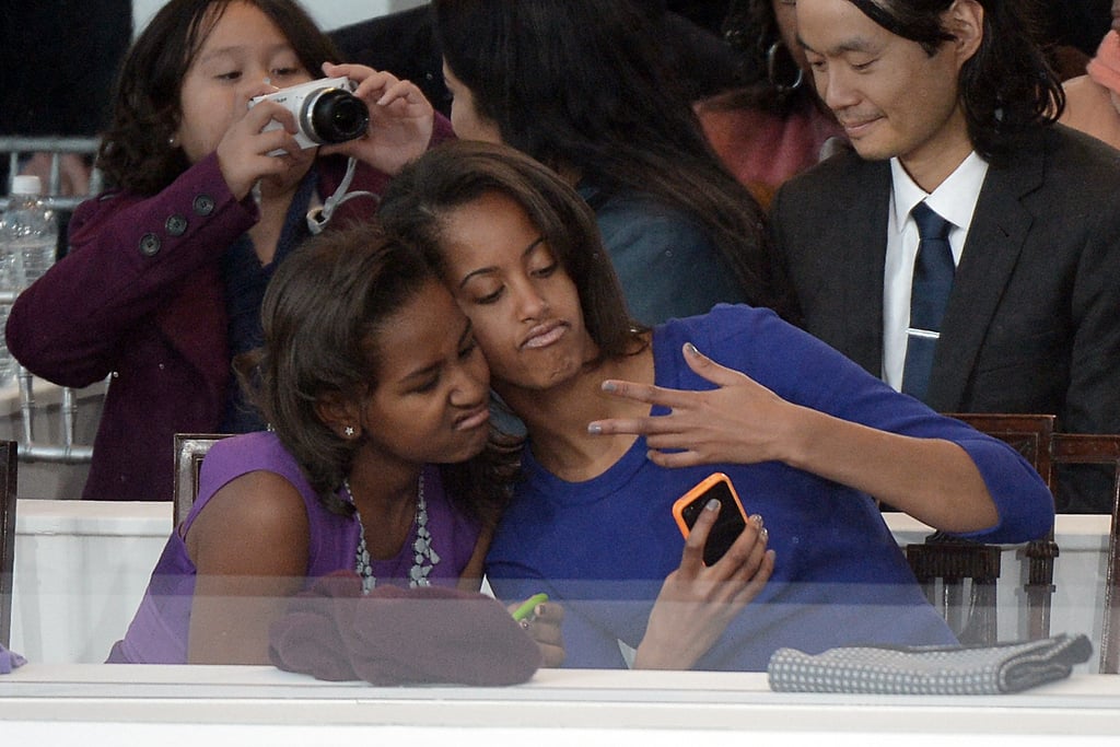 In January 2013, Malia Obama and Sasha Obama got silly for a selfie while sitting in the stands during the 2013 Presidential Inauguration Parade.