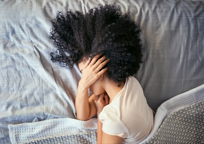 Shot of a young woman suffering from depression in her bedroom