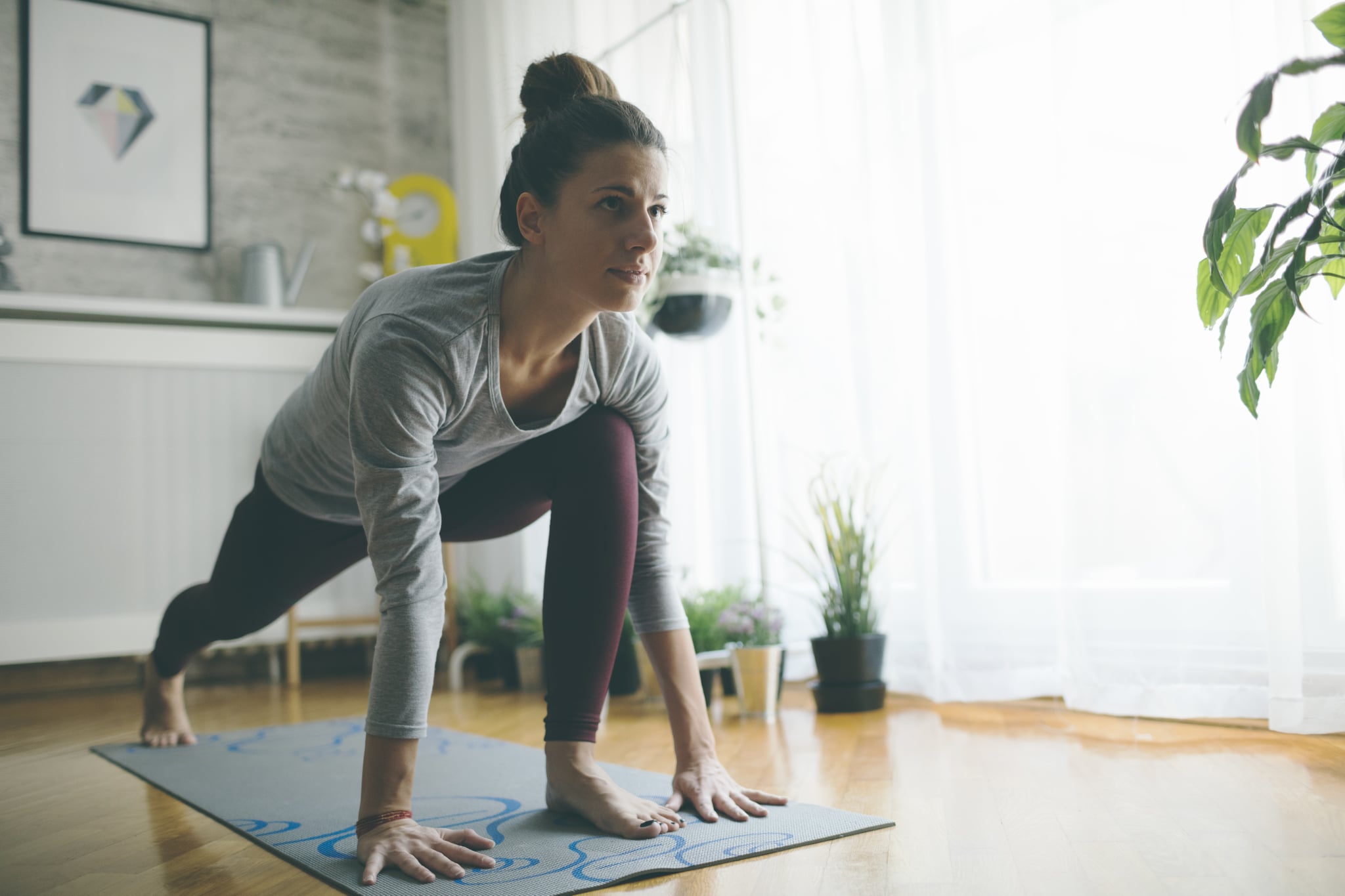 Young woman practicing iyengar yoga at home in her living room.