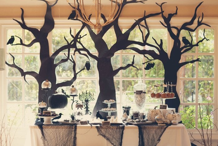 A little black lace and some tree silhouettes help make for a graceful tabletop. These trees strike a delicate balance between being a little spooky while still remaining classy.