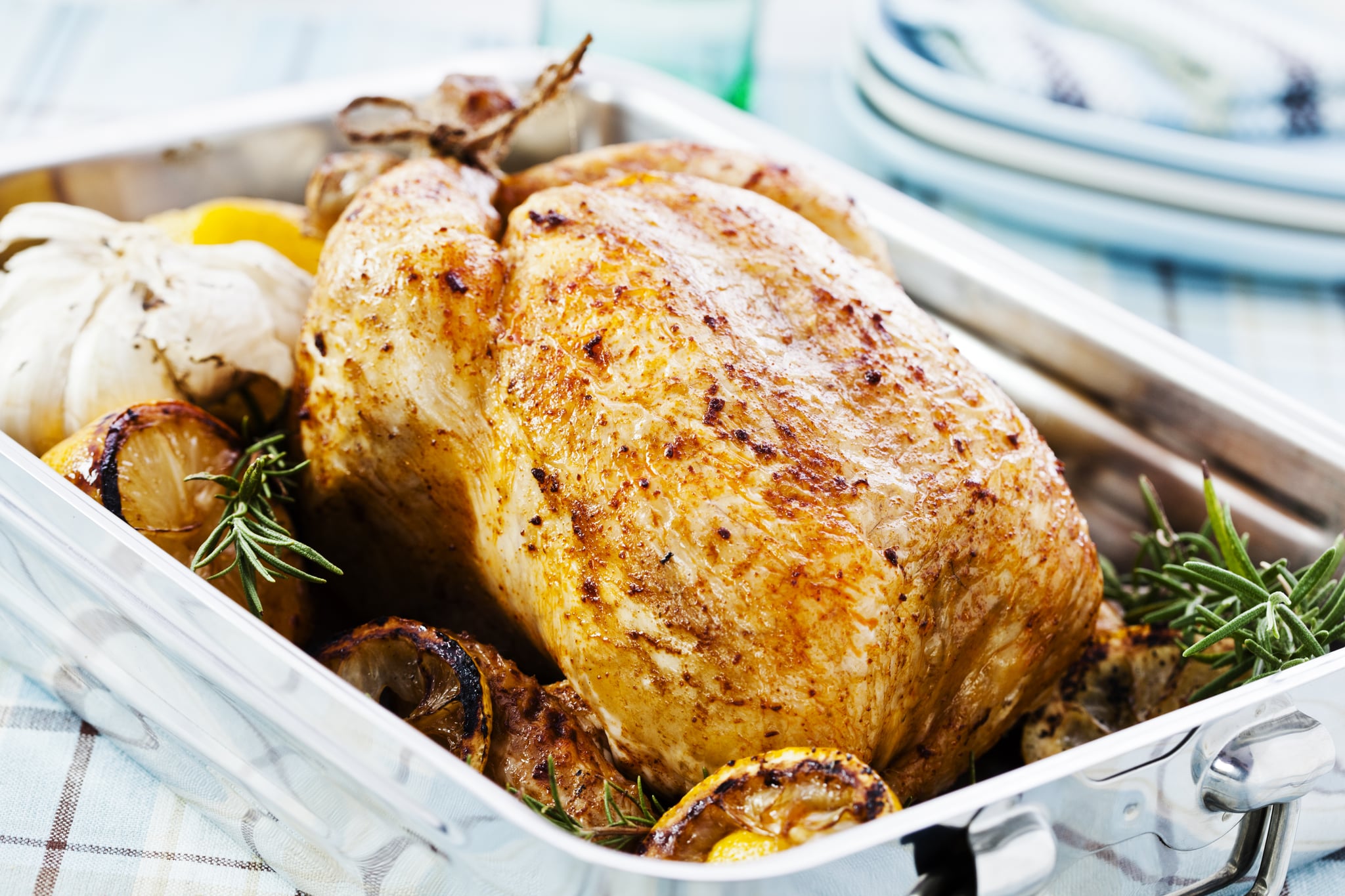 Roasted chicken in a pan with lemon, garlic and rosemary