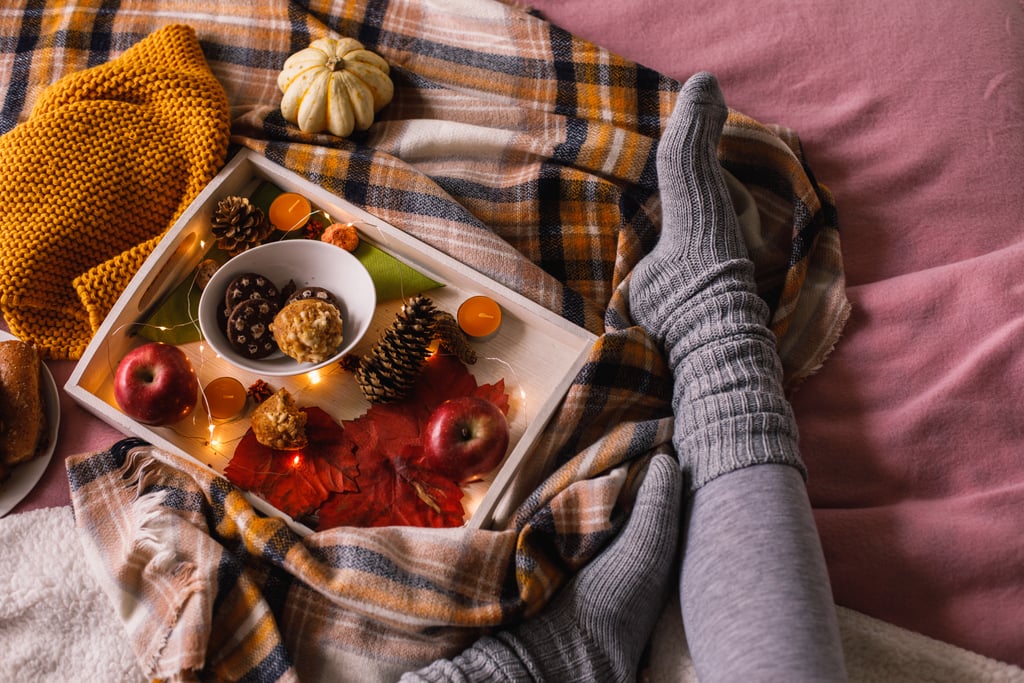 For this aesthetic, you'll want to gather the aforementioned blankets and candle, and you can also grab some hot coffee (or a pumpkin spice latte). Fashion-wise, the cozy Halloween aesthetic is all about chunky knit sweaters, leg warmers, plaid shirts, and velvet boots. A cozy-Halloween-themed party might look like gathering a bunch of friends for a potluck or collaging party by the fire. Musically, this aesthetic evokes Taylor Swift's "Folklore" or anything by The Lumineers or Bon Iver.
This aesthetic can overlap with the minimalist aesthetic, and it's similar to light Halloween, which typically favors more decorations than a general cozy aesthetic might. Cozy Halloween is also close to cottagecore Halloween, though a cottagecore aesthetic tends to be a little more specifically rustic.