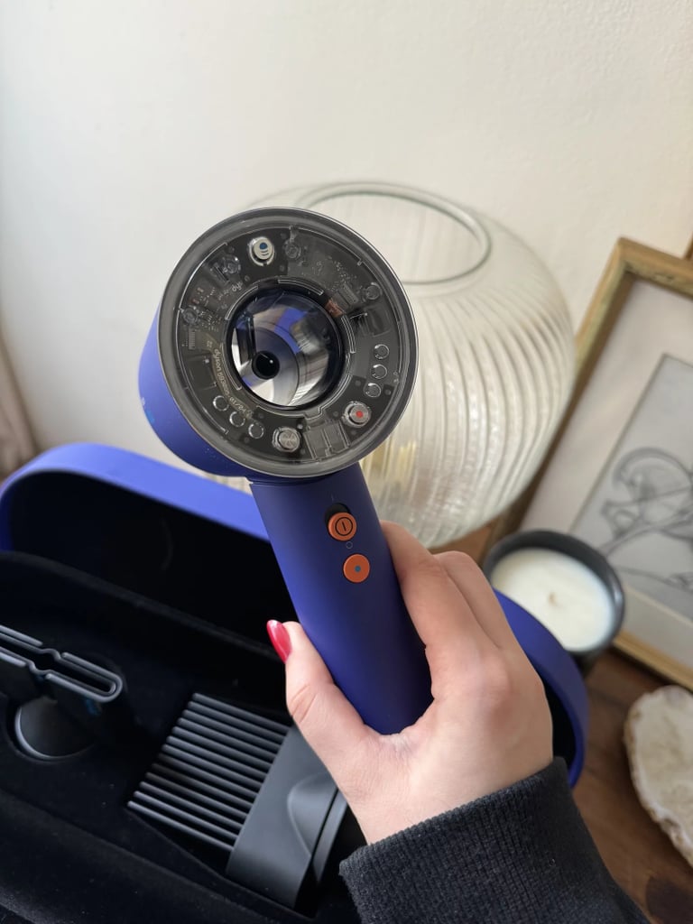 Dyson Supersonic Nural Hair Dryer ($350, originally $550)
Dyson's Supersonic Nural Hair Dryer is an upgraded version of the original Supersonic Hair Dryer with the addition of a scalp sensor. Along with the features in the Supersonic Hair Dryer, the Nural Hair Dryer has a scalp protect mode that has built-in sensors that can detect when the hair dryer is too close to the scalp and automatically lower the air temperature to decrease the risk of heat damage on the scalp. And it has LED lights to let you know the heat levels accordingly. It also has a pause detection feature that lowers the airflow and heat settings when the hair dryer senses that it's been put down. The Nural Hair Dryer is best for those who have a more sensitive scalp and want to be more cautious of heat damage. Check out the in-depth comparison between two hair dryers in this Supersonic Hair Dryer review.
Attachments: A styling concentrator, a gentle air attachment, a wide-tooth comb, a flyaway attachment, and an updated Nural diffuser that can be split into two pieces: a standard diffuser and a bowl-like shape when you disconnect the diffusing prongs.
Editor Quote: "The Nural Hair Dryer also has new technology that allows it to remember the settings you last used with each attachment, automatically adjusting them when you connect the piece to the machine. So, for example, if you last used your diffuser on low airflow and low heat, the next time you reattach the same item, it will enable those same settings....The traditional diffuser allows those with curly hair to dry their roots while minimizing frizz, while the new bowl capability allows you to dry the ends of wavy and curly hair with gentle, downward airflow." - Jessica Harrington, beauty section lead