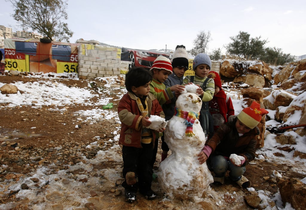 Young Syrian refugees built a small snowman in a makeshift refugee camp in the Bekaa Valley.