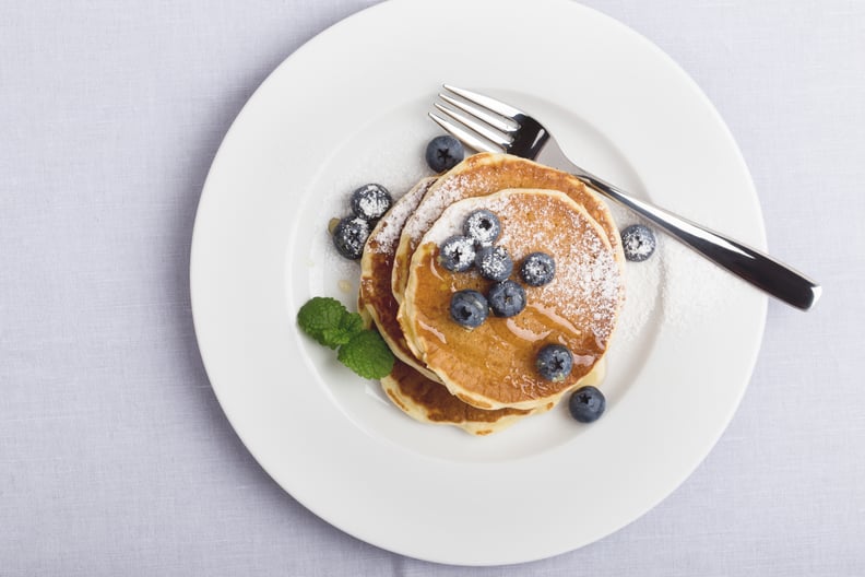 Blueberry pancakes on white plate viewed from above