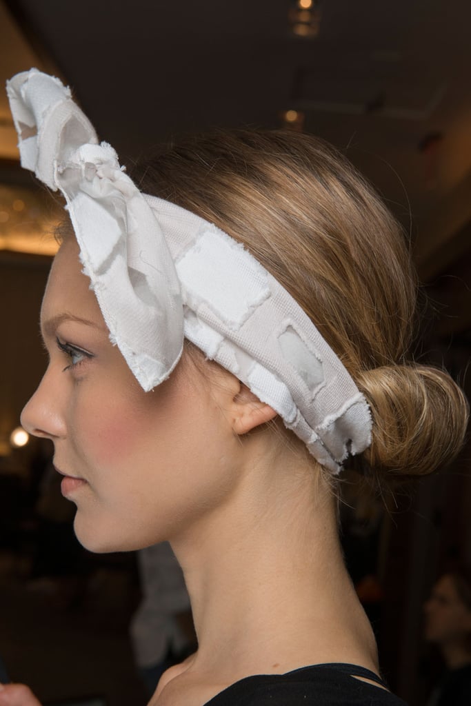 While the croissant bun spotted backstage at the Lela Rose runway show is one of our favorite options for styling second-day hair, it's also the perfect look to try if you're missing a hair tie as well (talk about a win-win). Even though this look originally featured a small hair elastic to bring the hair into a low ponytail before rolling it into a bun, you can skip that step entirely and choose a bandana to hold the hair in place and achieve the same effect.
