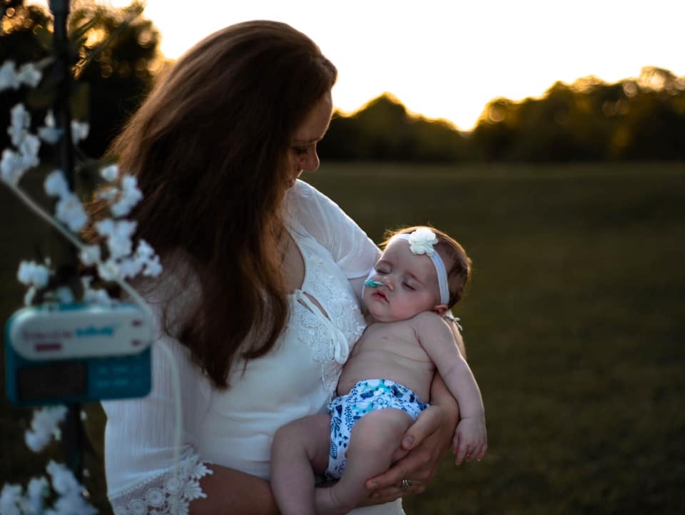 "Her name is Hailey, but we call her Bug. She's a delightful little 5-month-old! She was born full-term, but from the get-go had issues with nursing and even taking a bottle. Weeks led into months of her not eating correctly due to an improper swallow, dairy, soy, and coconut allergies, and reflux issues. She failed a swallow study and then had a severe case of oral thrush so she had a nasal tube inserted. She has an Nasojejunal Tube, meaning she gets fed by pump continuously into her intestine rather than stomach because she has a history of aspirating. Since then, she's failed a second swallow study; in fact, the second one was worse than the first, and she no longer takes anything by mouth. 
We're working with Vanderbilt hospital to do tests in order to find out the cause of her swallow problems. We're also working with feeding therapy to encourage her to learn how to eat and drink eventually, and will be adding physical therapy to the list, too. Our journey is just beginning and we have a long way to go, but she's a fighter!"