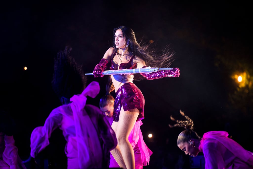 Dua Lipa is hopping from show to show all over the world, and her striking costumes are coming along for the ride. Just days after headlining the Osheaga Music and Arts Festival in Montreal, Quebec, in a bedazzled lacy catsuit, the singer kicked off the Sunny Hill Festival — an international music event organized by herself and her father, Dukagjin Lipa, in Pristina, Kosovo — on Aug. 4. She traded her signature concert catsuit for a custom Valentino by Pierpaolo Piccioli creation: a bra top, a midrise miniskirt, opera gloves, and booties, all in the same metallic fuchsia. Enrobed in a matching cape for the performance, Lipa sang and danced her heart out for the third edition of her music festival. 
Shortly after her set, the singer shared the behind-the-scenes process of creating the sequin ensemble on Instagram, posting snaps of Piccioli himself sketching the designs. She also showed glimpses of what looks to be a Valentino showroom, which was filled with clothing in the famous vibrant pink hue. The creative director previously described it as "the color of love, community, energy and freedom."
Working with her stylist Lorenzo Posocco on her "Future Nostalgia" tour outfits, Lipa has mostly worn lace catsuits by designers like Mugler and Balenciaga, typically embellished with matching opera gloves. Off the stage, the singer has been spotted in effortlessly cool  designer looks, most recently a Bottega Veneta pinstripe shirtdress paired with over-the-knee boots by the same designer for a casual day in Kosovo earlier this week.
Get a closer look at Lipa's latest performance outfit ahead.
Related:
Dua Lipa Styled a Pink Bra With Those Viral 6-Inch Platform Pumps