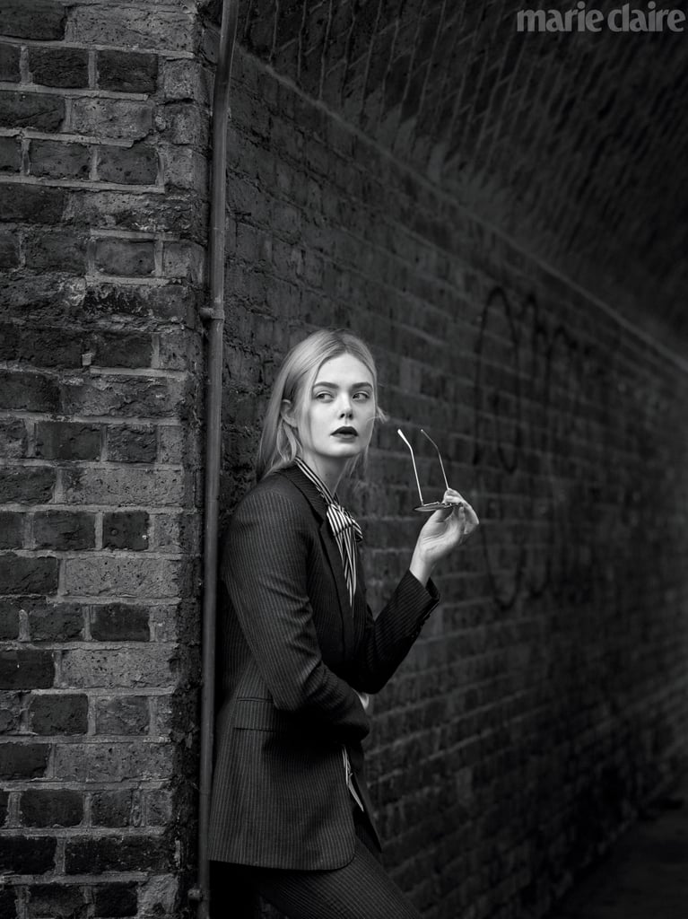 Elle Fanning wearing a Celine by Hedi Slimane jacket, vest, top, pants, and a pair of Cartier sunglasses.