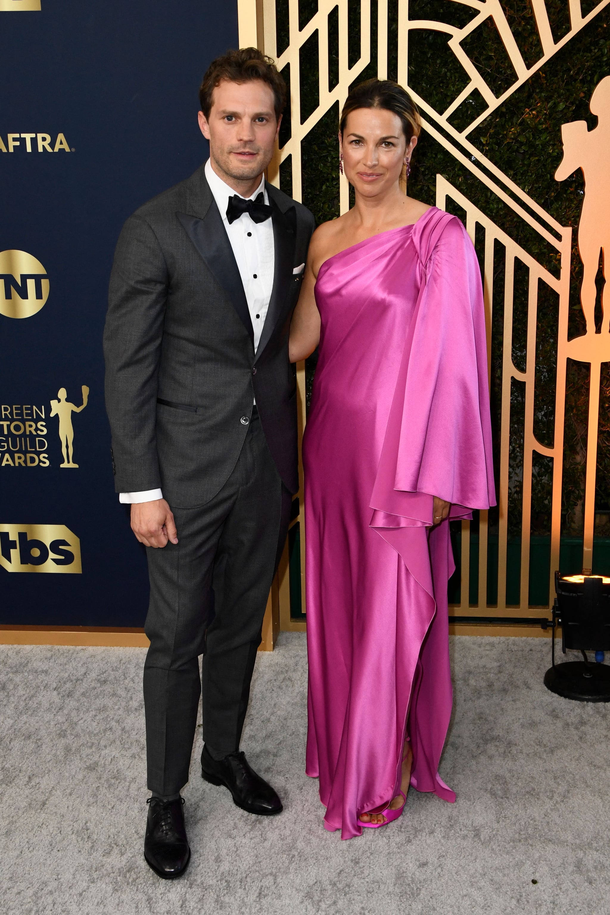 Irish actor Jamie Dornan (L) arrives with his wife, musician Amelia Warner, for the 28th Annual Screen Actors Guild (SAG) Awards at the Barker Hangar in Santa Monica, California, on February 27, 2022. (Photo by Patrick T. FALLON / AFP) (Photo by PATRICK T. FALLON/AFP via Getty Images)