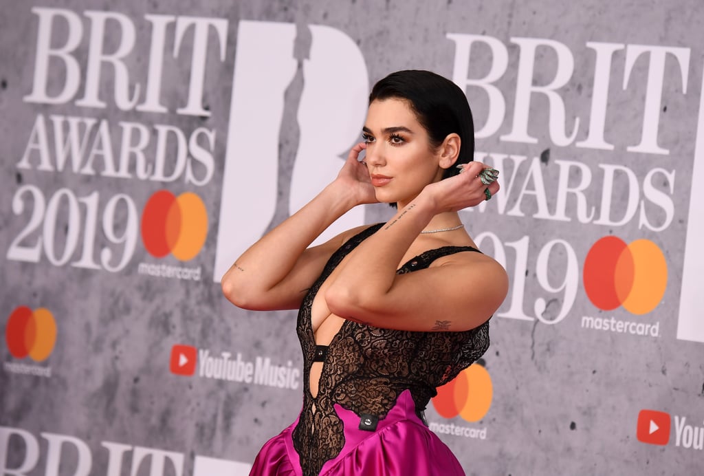 Dua Lipa was the de facto prom queen of the 2019 Brit Awards. At the award show on Feb. 20 in London, the singer wore a Christopher Kane dress straight off the runway — no, really, the dress appeared in the designer's Fall 2019 show during London Fashion Week a mere two days before on Feb. 18. The daring gown features a plunging lace top attached to a poofy satin skirt reminiscent of Bianca Stratford's prom dress in 10 Things I Hate About You. ('90s kids, you'll get the reference.) See Dua give the dress its lightning-fast red carpet debut ahead.

    Related:

            
            
                                    
                            

            Dua Lipa&apos;s Grammys Gown Was So Extra, a Guy Had to Carry the Train