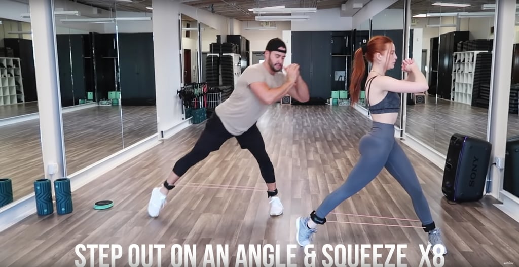 Put on some ankle bands if you have them. Step one leg out and put your foot at an angle before bringing it back in and squeezing your glutes in a squat.