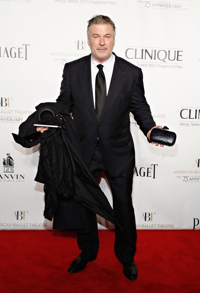Alec Baldwin's hands were full with his wife Hilaria Baldwin's accessories and coat on the ABT Gala red carpet in NYC on Wednesday.