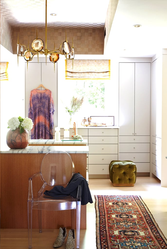 The master suite's closet is actually more of a dressing room and, not surprisingly, Baylin's prized space. Patterned wallpaper, wood-veneer detailing, and an agate-slice chandelier exude bohemian glamour.