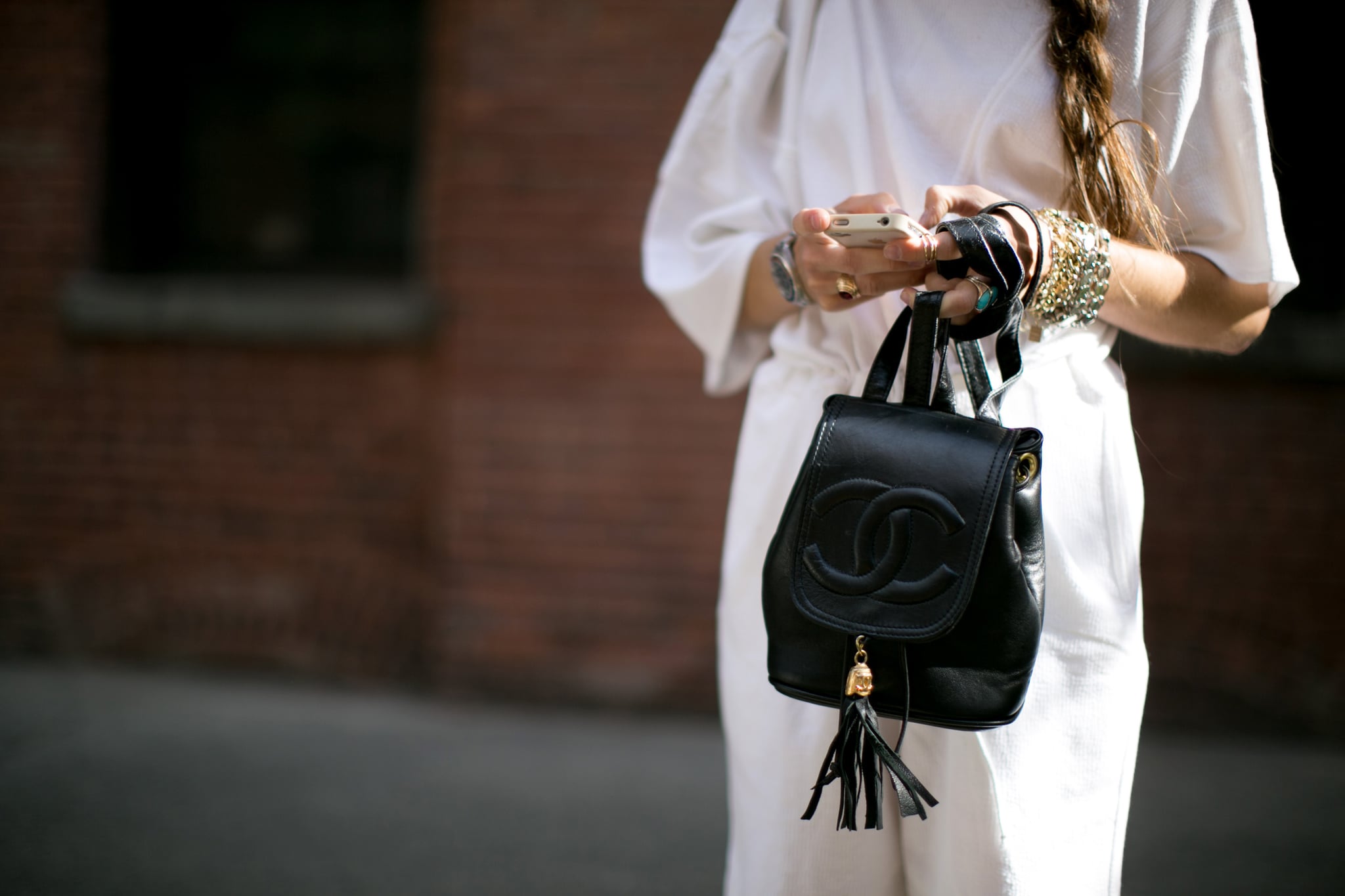 toting a tassled Chanel backpack 