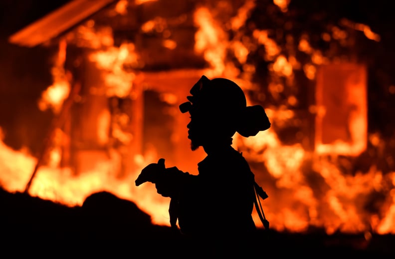 A firefighter is on the scene as flames destroy a home.