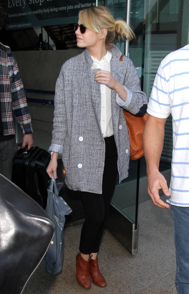 Forget traveling — we'd happily re-create Emma Stone's look for a day at the office! Black and brown work together perfectly when it comes to trousers and ankle boots, and her double-breasted jacket is a menswear-inspired update to the regular blazer.