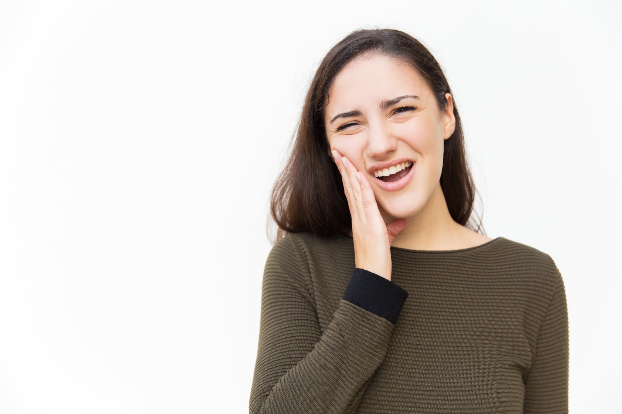 Upset woman with pain grimace suffering from toothache. Young woman in casual standing isolated over white background. Dental problem concept