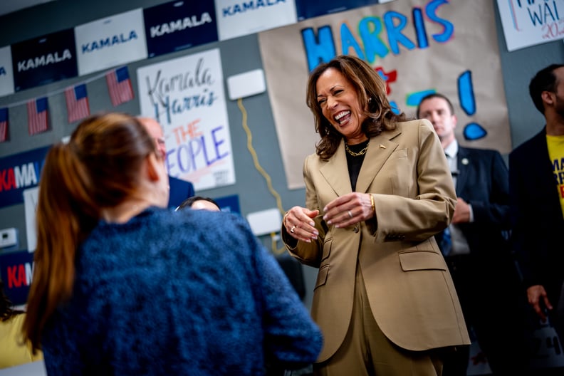 Democratic presidential candidate, U.S. Vice President Kamala Harris visits a campaign office on August 9, 2024 in Glendale, Arizona. She laughs with a campaign staffer in a room with signs for her candidacy.