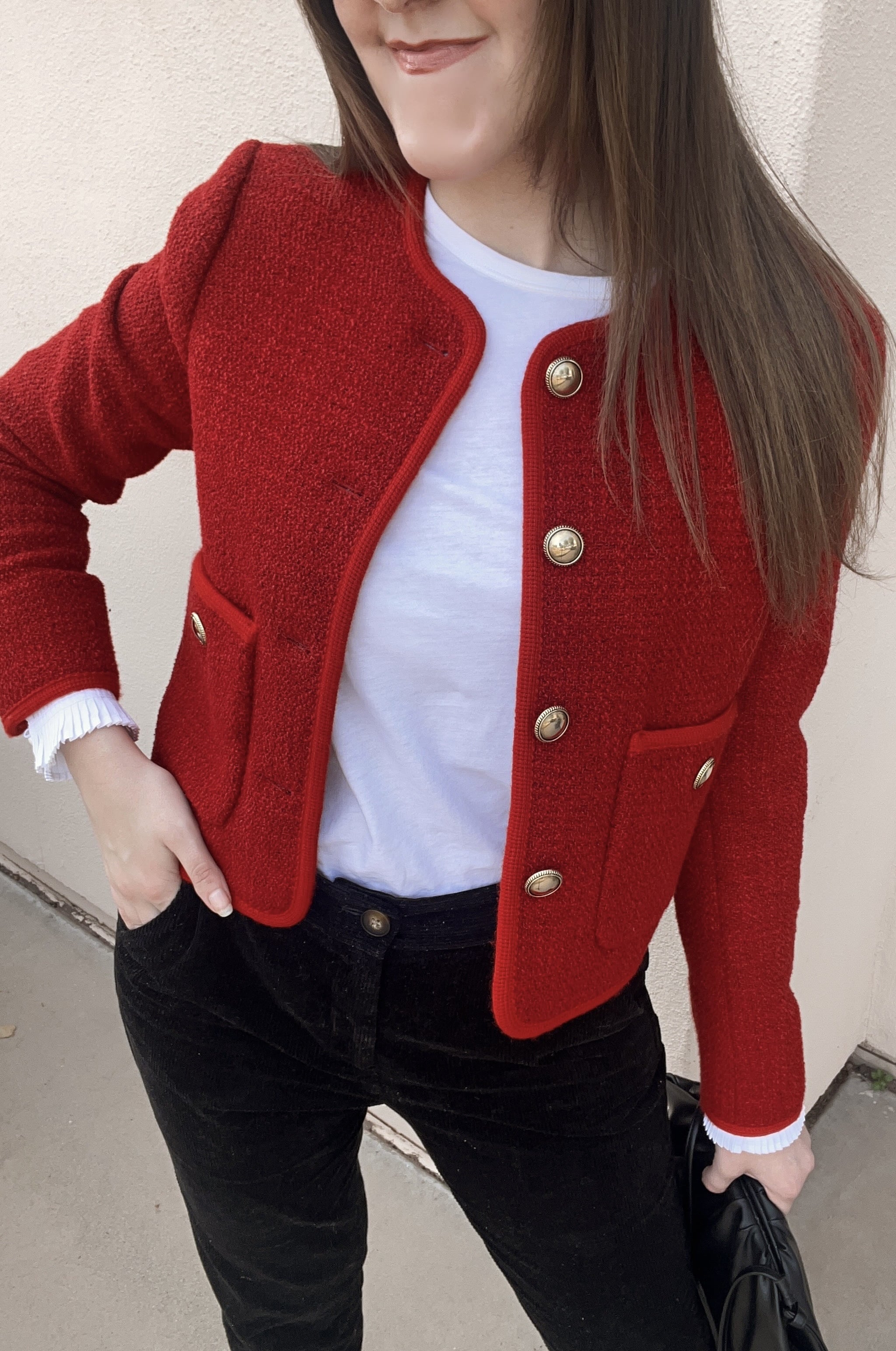 woman wearing me and em red boucle jacket, corduroy pants, and white layering shirt