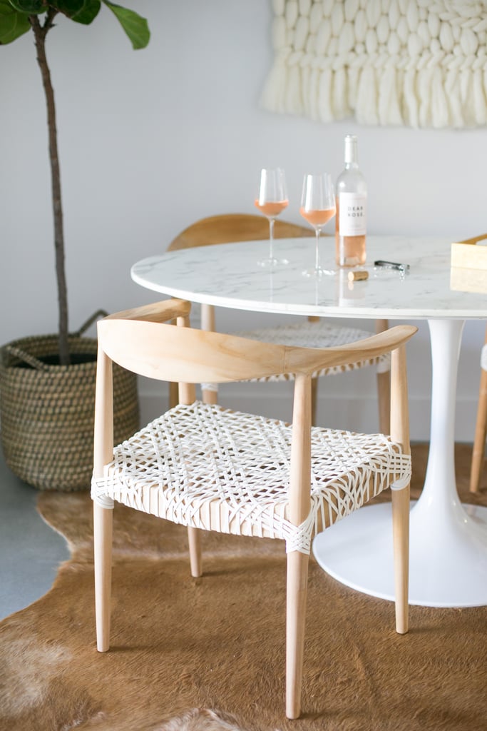 In the dining nook, a sleek marble tulip table ($654) is offset by natural textures such as the reclaimed teak chair ($240) and cowhide rug ($400).