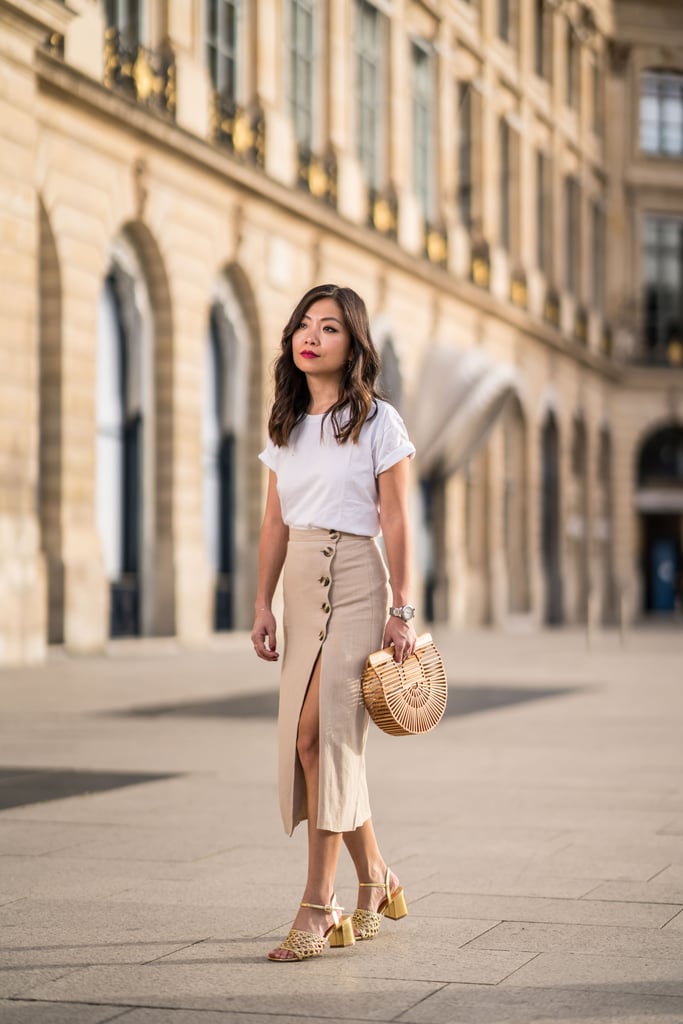 For brunch, tuck a white tee into a midi skirt and finish with a wooden bag and sandals for a Summery feel.