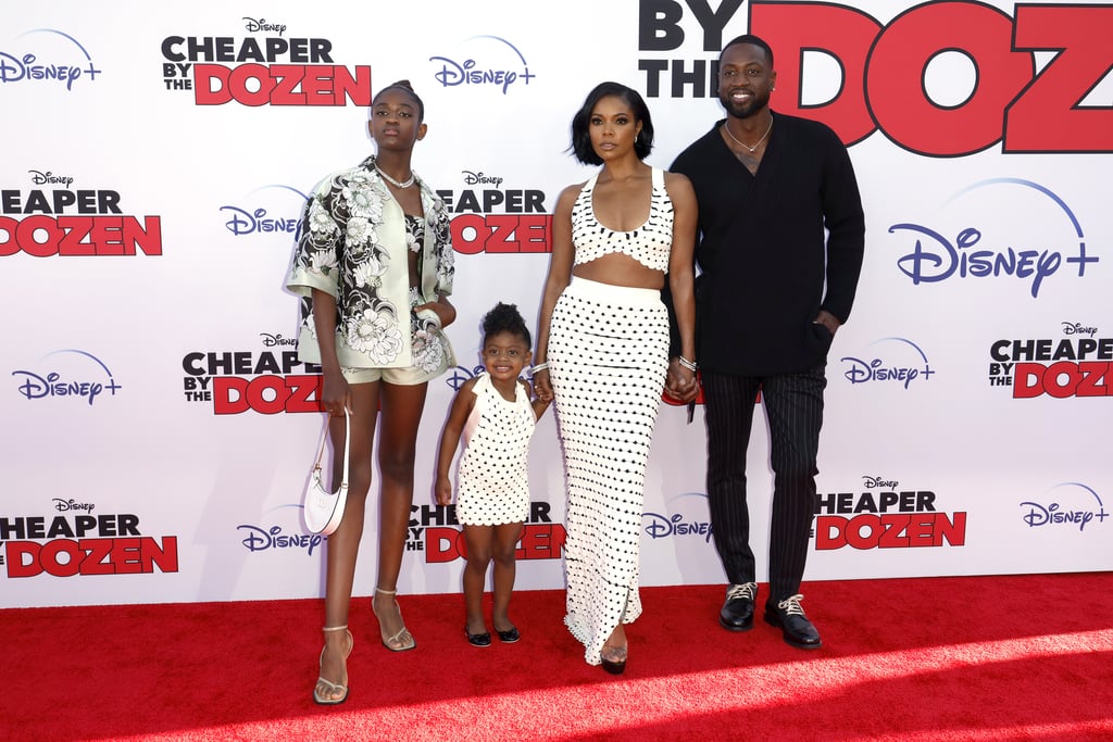 And the award for most stylish family goes to . . . the Wades. Gabrielle Union, Dwyane Wade, and their kids Zaya and Kaavia James hit the red carpet on Wednesday evening for the premiere of "Cheaper by the Dozen." The remake, which releases March 18 on Disney+, stars Union as the mom of 10 children, alongside Zach Braff as her husband. Union's family off screen supported her in style, all of them coordinating for the occasion. This marks the first time the family have appeared on a red carpet together, and they made sure to make a statement.
Styled by Thomas Christos Kikis, Union and Kaavia posed in matching Altuzarra looks from the designer's fall 2022 runway. Union wore a cropped halter top and maxi skirt in a scalloped black-and-white pattern, which she paired with Andrea Wazen heels and an assortment of rings and bracelets from Bulgari. The 3-year-old coordinated in a mini halter dress of the same design, plus black ballet flats. While the duo have worn identical looks before, it's the first time they're walking a red carpet matching in tandem. 

    Related:

            
            
                                    
                            

            Please Enjoy Kaavia James, Unboxing Queen, Opening Her New Valentino Purse
        
    
While Union and Kaavia reveled in their moment, 14-year-old Zaya, a budding fashion influencer in her own right, rocked her own standout look. With the help of stylist Sydney Engelhart, she dressed in a three-piece Valentino set consisting of a bandeau top, shorts, and short-sleeved jacket. The intricate florals from the spring 2022 collection complemented Zaya's mini white hobo bag from the brand, nude sandals, and Bulgari chain necklace. 
Wade rounded out the family's outfits in a simple black ensemble. Dressed by Jason Bolden, the former NBA player wore a knit Dunhill sweater, pinstripe trousers from Richfresh, and Gucci sneakers. Like the rest of the family, he also accessorized with Bulgari jewelry. Ahead, get a closer look at the fashionable family and their chic outfits.

    Related:

            
            
                                    
                            

            Gabrielle Union and Dwyane Wade Have a Topless Fitting in Etro, a Date Night in Prada