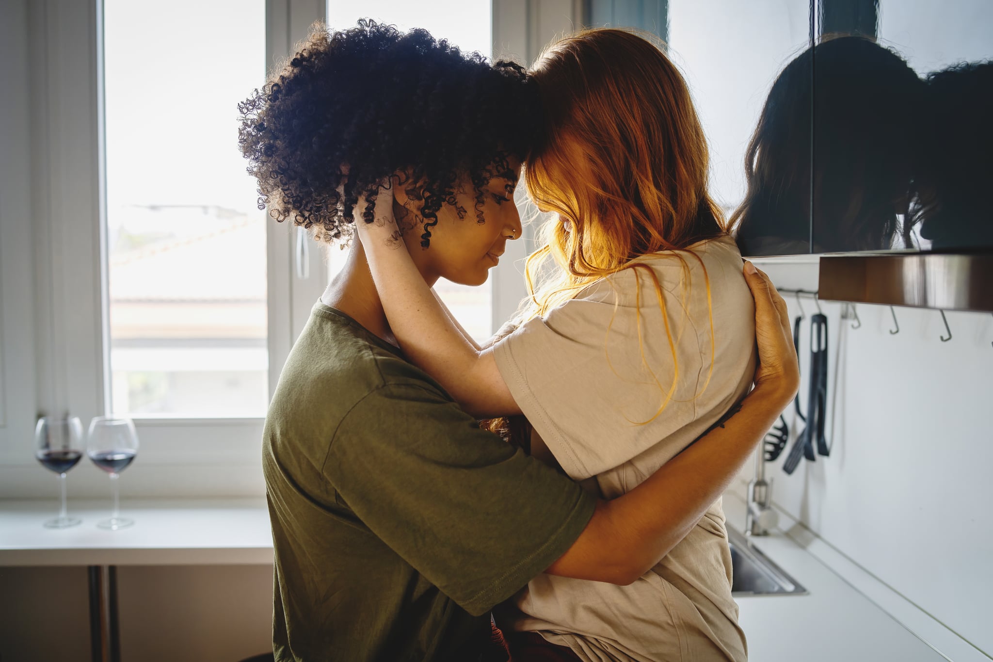 Lesbian Couple Leaning Foreheads Against Each Other Wrapped In Each Other's Embrace