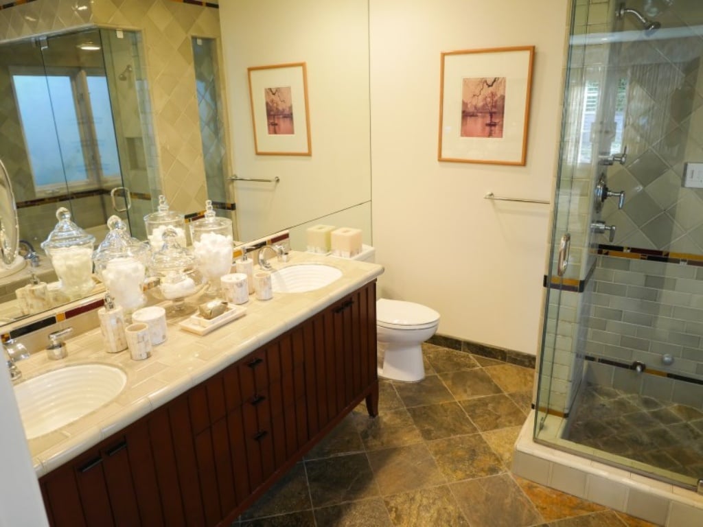 This bathroom includes tiled flooring and two sinks. 
Source: Sotheby's Realty