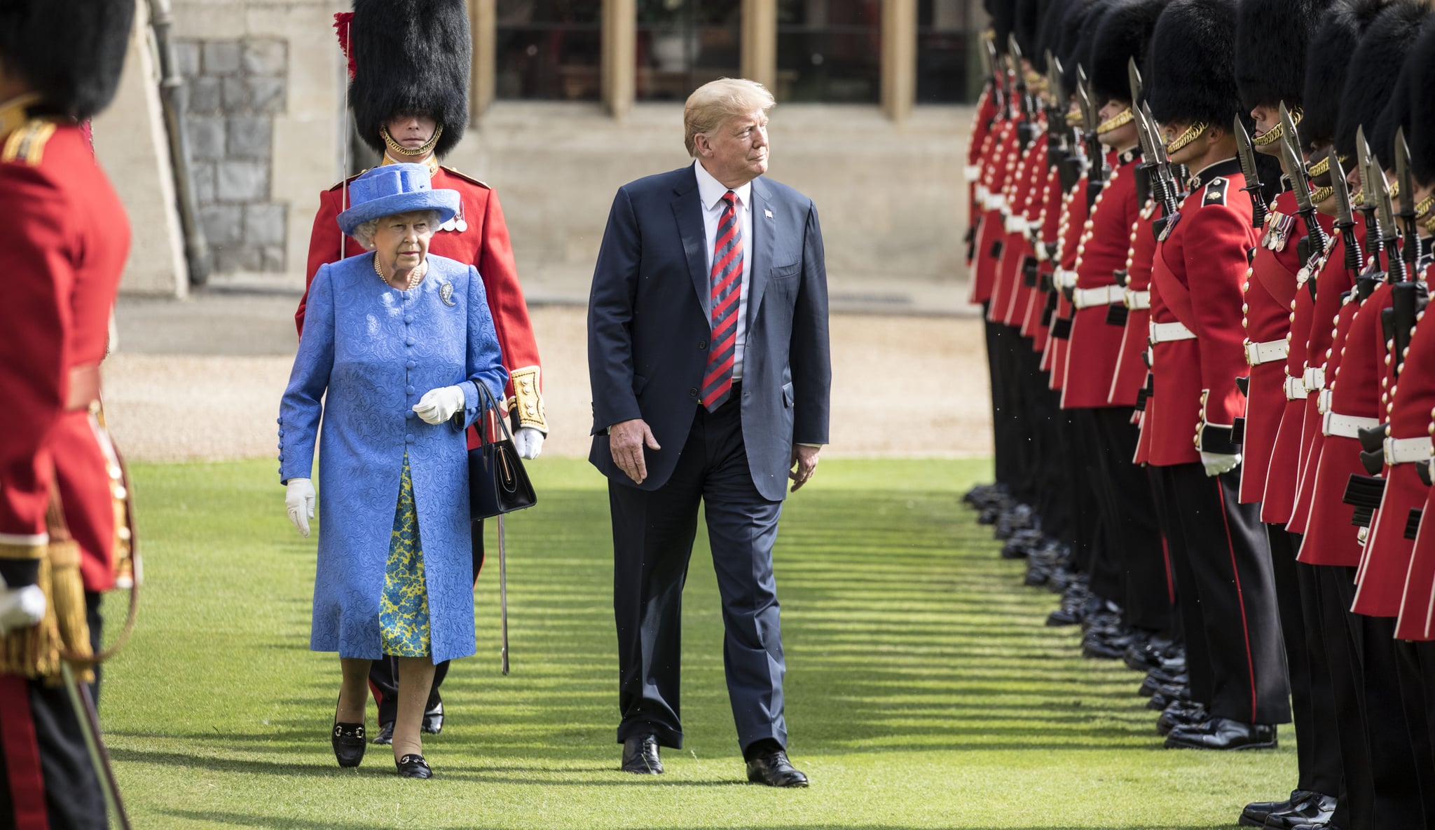 WINDSOR, ENGLAND - JULY 13:  U.S. President Donald Trump and Britain's Queen Elizabeth II inspect a Guard of Honour, formed of the Coldstream Guards at Windsor Castle on July 13, 2018 in Windsor, England.  Her Majesty welcomed the President and Mrs Trump at the dais in the Quadrangle of the Castle. A Guard of Honour, formed of the Coldstream Guards, gave a Royal Salute and the US National Anthem was played. The Queen and the President inspected the Guard of Honour before watching the military march past. The President and First Lady then joined Her Majesty for tea at the Castle.  (Photo by Richard Pohle  - WPA Pool/Getty Images)