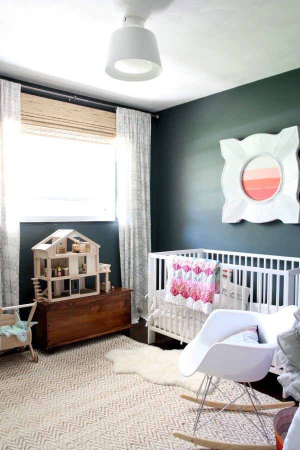 Transformation alert! These parents ditched the dubious old carpet, peeling paint, and deteriorating baseboards for a palette that makes the most of contrasting colors and clean lines. Long drapes seem to heighten the ceiling of this small space. An Eames molded plastic rocker takes it to the next design level — and would provide a mom like Nicole with a spot to nurse the little one.