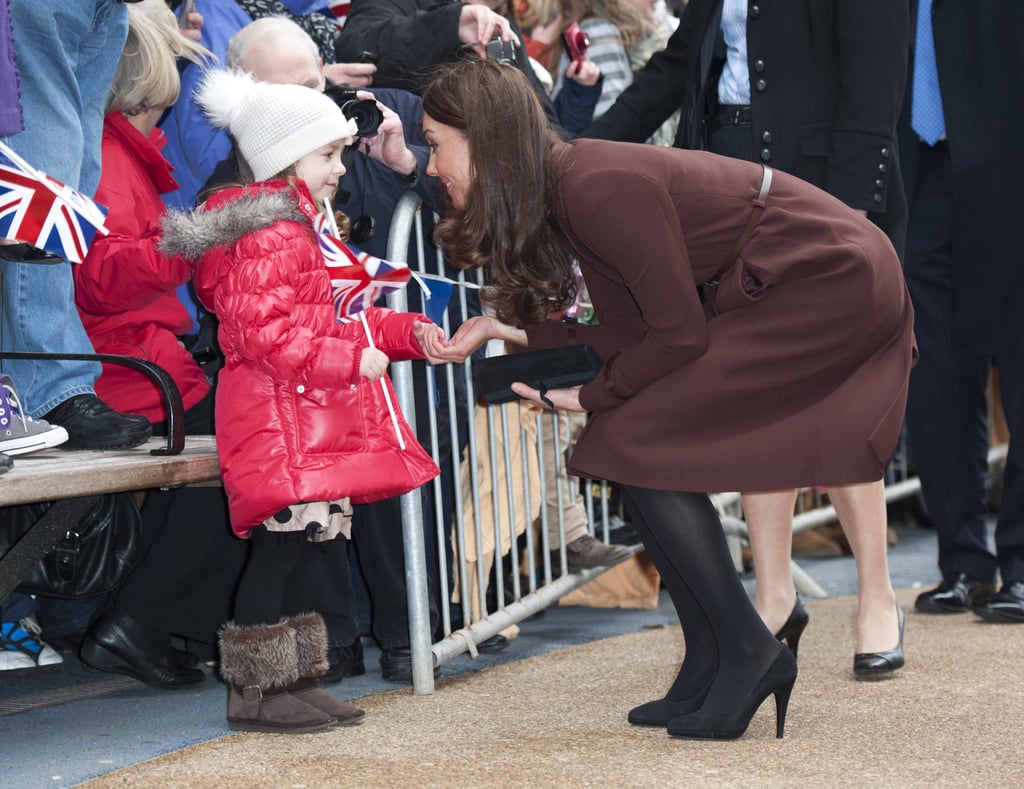 Kate bent down to greet a little girl during a solo trip to the Alder Hey Children's Hospital in Liverpool, England, back in February 2012.